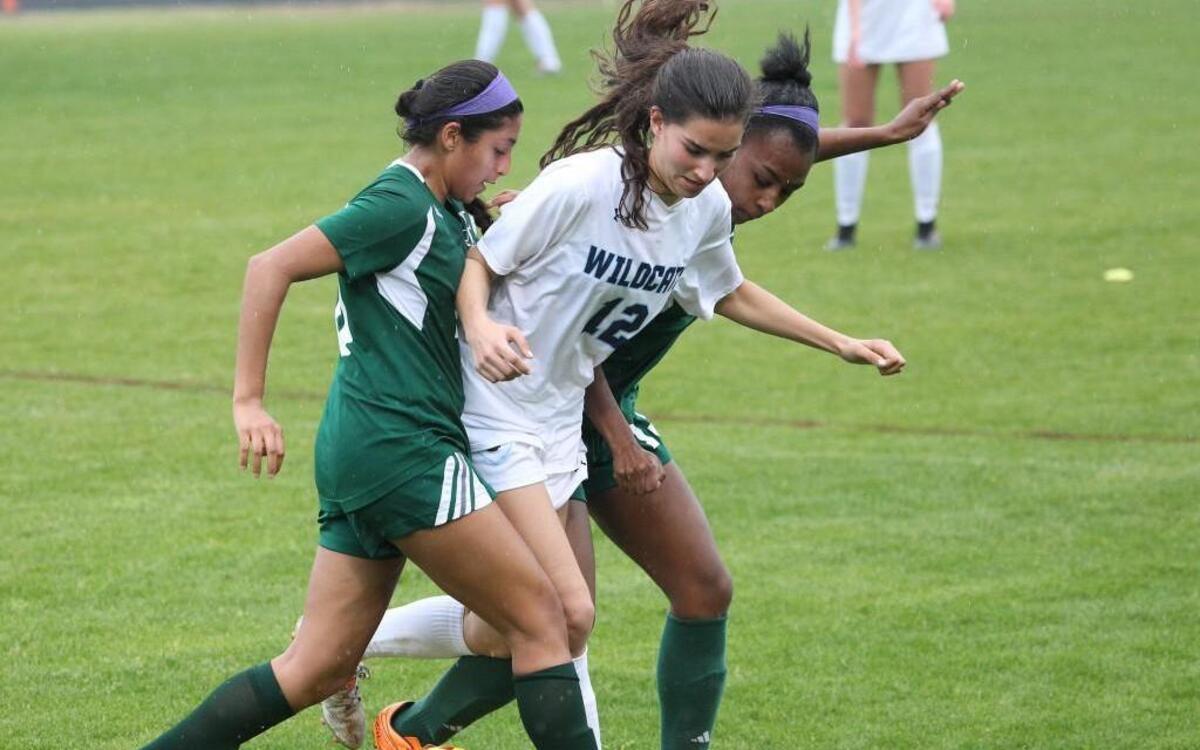 Millbrook's Mara Tate (11) splits Enloe's Pragya Sonker (20) and Jasmine Betts (13) during the Enloe Eagles high school soccer game with the Millbrook Wildcats high school on April 5, 2017. Millbrook won the game 5-0.