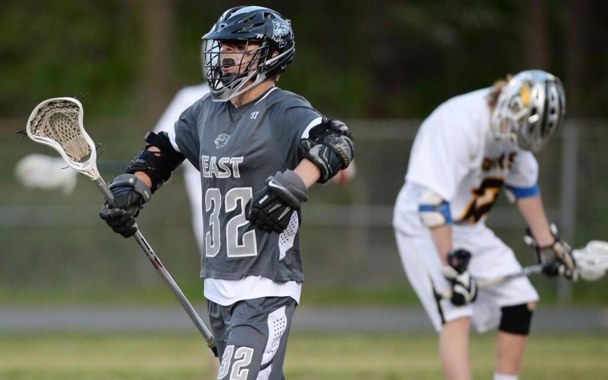 Chris Cox (32) of East Chapel Hill celebrates after scorings a goal against Sean Voelkel, right, of Chapel Hill. The Chapel Hill Tigers played the East Chapel Hill Wildcats in Chapel Hill, N.C. on Friday, April 8, 2016. East Chapel Hill won 12-8.