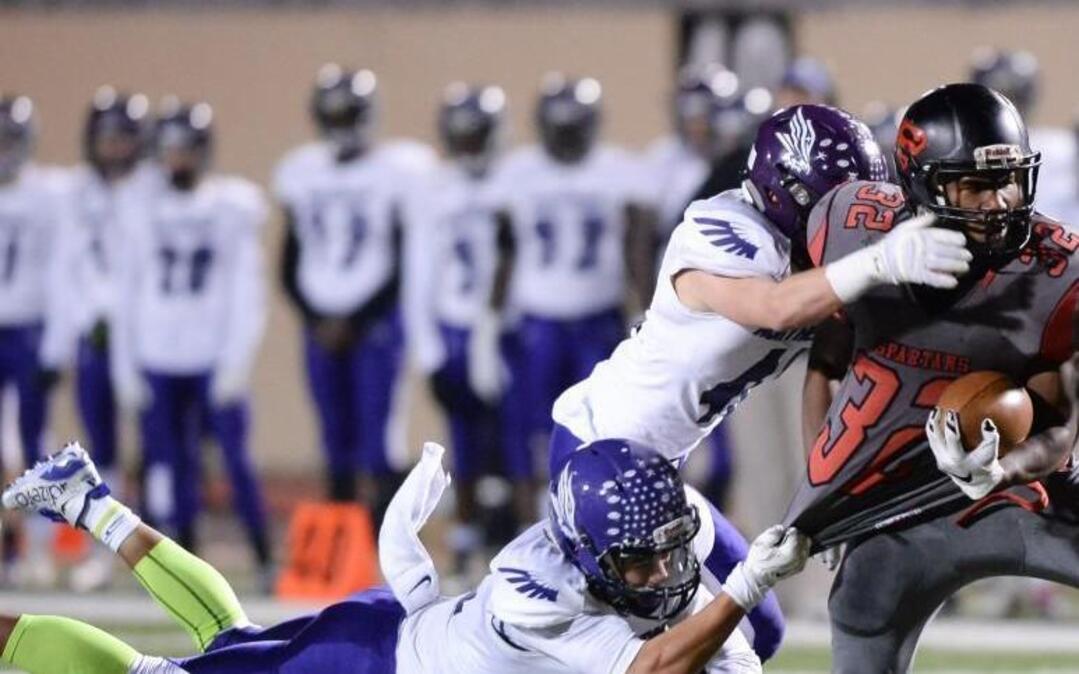 Myron Fraizer (32) of Southern carries the ball against Jordan Lane, left, and Brad Cranford, center, of Northern Guilford. The Southern Spartans played the Northern Guilford Nighthawks at the Durham County Memorial Stadium in Durham, N.C. on Friday, December 4, 2015.
