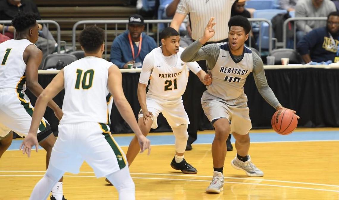 Jayden Gardner (40) of Heritage dribbles against Anthony Allen (21), Miles Pauldin (10), and Matt Smith (1) of Independence. The Heritage Huskies played the Independence Patriots in a boys basketball game that counted for the NCHSAA 4A championship that took place at the UNC Dean Smith Center in Chapel Hill, N.C. on Saturday, March 10, 2018. Independence won 71-60.