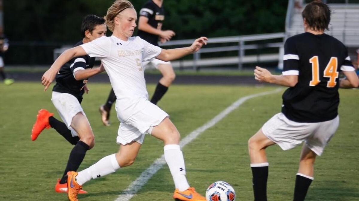Holly Springs' Davis Edwards (5) dribbles through traffic during Fuquay-Varina's soccer game at Holly Springs on Wednesday, September 7, 2016. Holly Springs won the game 2-1 in extra time.
