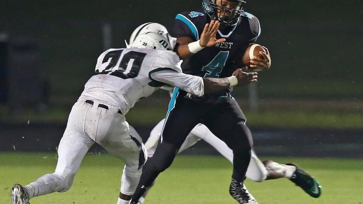 West Johnston's J.T. Houston (4) picks up additional yardage after his pass reception as Southeast Raleigh's Maurice Nelson (20) comes in to make the stop during a game played between the West Johnston Wildcats and the Southeast Raleigh Bulldogs played in Benson, N.C. on Friday, September 23, 2016.