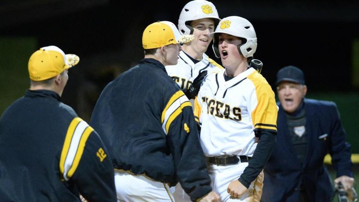 Garrett Liebe, right, of Chapel Hill celebrates along his teammates, Anthony Castellano, left, Ben Kelley, second from left, and Nick Elston, second from right, after scoring in the 6-th inning. The Chapel Hill Tigers played the Orange Panthers in a baseball game that took place in Chapel Hill, N.C. on Tuesday, April 5, 2016. Chapel Hill won 3-2.