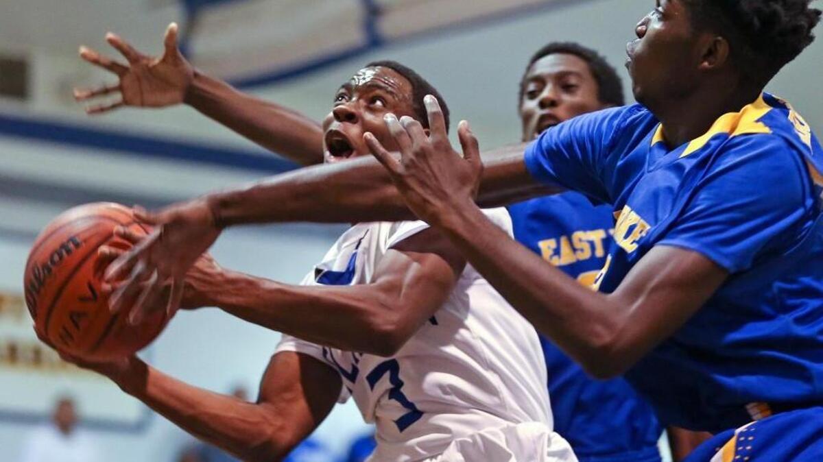 Clayton’s Tre Armstead (3) goes into the middle to put up a shot as East Wake’s Mason Harrell (23) defends.