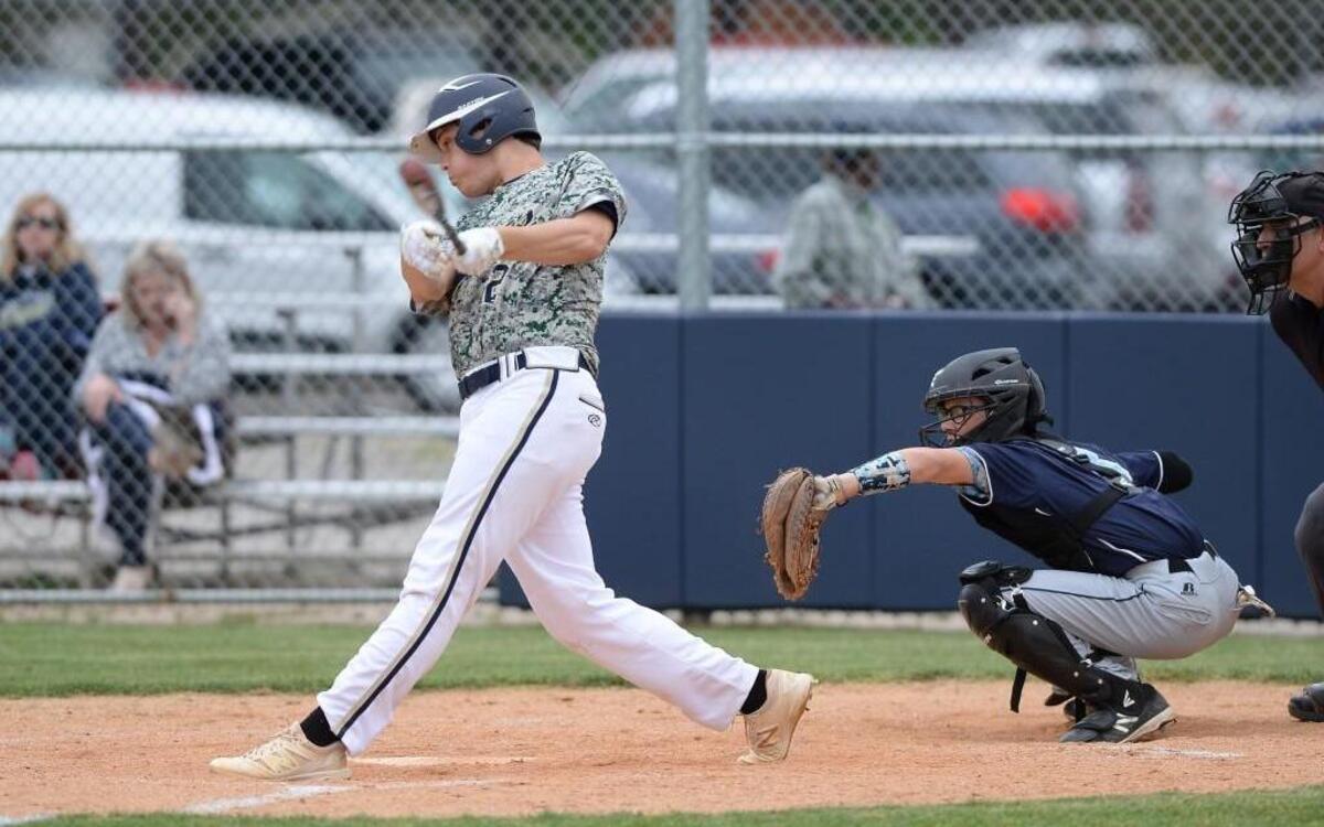 Cody Stainback (2) of Northern Vance hits the ball in front of Clay Faulkner, right, of Southern Vance. The Northern Vance Vikings played the Southern Vance Raiders in a baseball game that took place in Henderson, N.C. on Wednesday, April 19 2017. Northern Vance won 13-3.