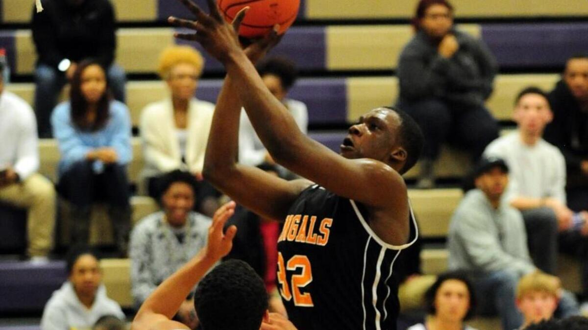 Fuquay-Varina's Moriba Diaby (32) shoots over Holly Springs' Broderick Taylor (left) during the boys basketball game, which was played in Holly Springs Tuesday, January 26, 2016. Fuquay-Varina won 57-52.