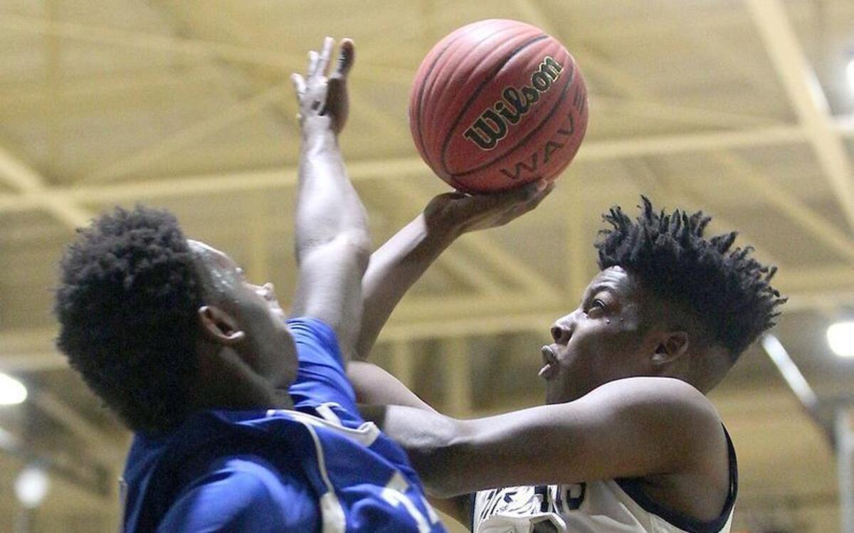 Smithfield-Selma's Isaiah Watson (23) drives hard against Triton's Josh Raiford (12) during Smithfield-Selma's Spartans basketball game against the Triton Hawks High School Tuesday, February 9, 2016, in Smithfield, N.C.