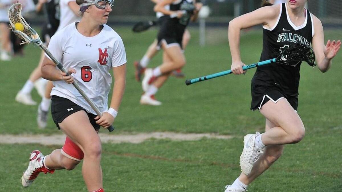 Middle Creek's Madison Boudreau (6) sprints with the ball downfield while defended by Green Hope's Maddie McKinley (15) during the second half. The Middle Creek Mustangs took on the Green Hope Falcons in lacrosse at Middle Creek High in Apex, N.C. on March 22, 2016. Middle Creek won 15-2.
