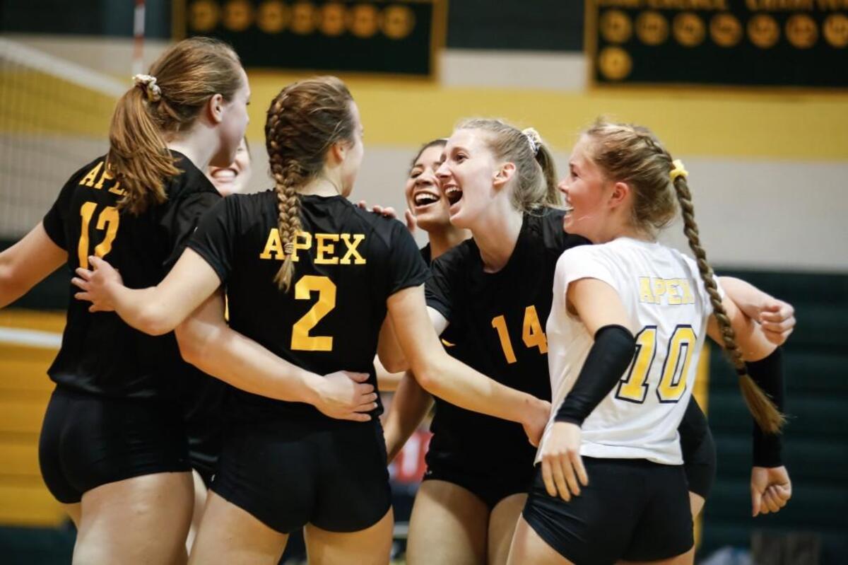 Apex players, from left, Anna Credle (12), Shelby Poliachik (2), Madi Rudd (14) and Margo Harrell (10) celebrate a point during Leesville Road's playoff volleyball game at Apex on Wednesday, October 26, 2016. Apex won the game 3-0.