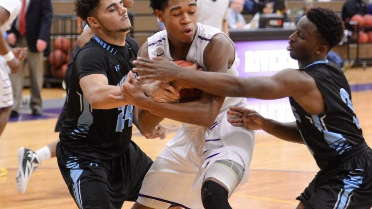 Isaiah Reddish, center, of Riverside wins a rebound against Seth Lowery, left, and Latrell Lloyd, right, of Overhills. The Riverside Pirates played the Overhills Jaguars in a boys basketball game that took place in Durham, N.C. on Tuesday, February 23, 2016. Riverside won 79-56.