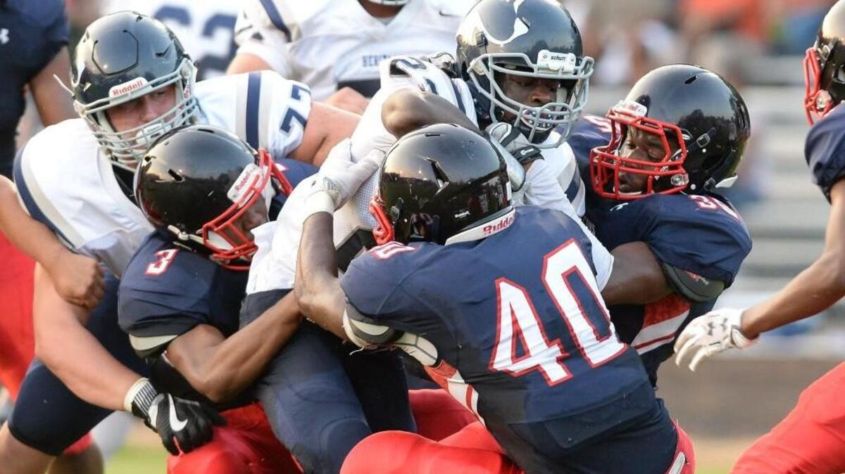 George Kotee, center, of Heritage breaks through the Falcons defense, Bruce Black (3), Kirkland Mckenzie (40) and Tristan Edmond, right, of Jordan to score the first touchdown for the Huskies. The Jordan Falcons played the Heritage Huskies in a football game that took place in Durham, N.C. on Friday, September 9, 2016. Heritage won 32-17.