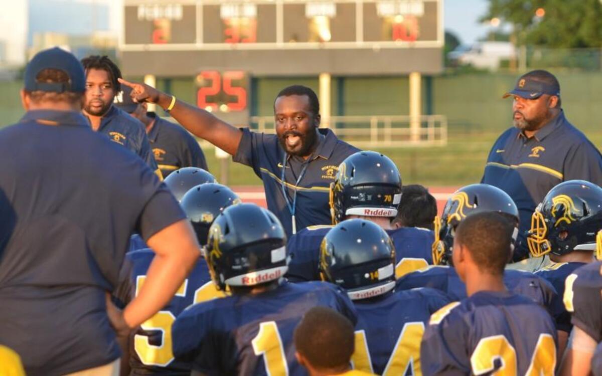 R.J Wilson, center, head coach of Northern instructs his team during a timeout. The Northern Knights played the Orange Panthers in a football game that took place at the Durham County Memorial Stadium in Durham, N.C. on Friday, August 26, 2016. Orange won 21-13.