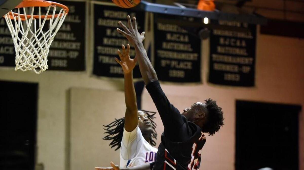 Franklinton's Delton Davis (12) shoots over Louisburg's Al'Malik Cannady (23) in Louisburg, N.C. on Friday, December 9, 2016. Franklinton won 80-61.