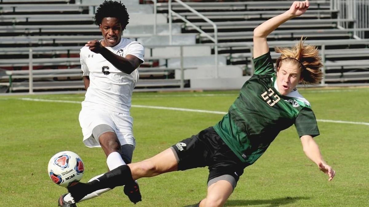 Cardinal Gibbons' Justin Dieter (right) kicks the ball away from Hough's Savon Brathwaite. The Cardinal Gibbons Crusaders beat the Hough Huskies 2-1 in the NCHSAA 4A mens soccer championship game, November 18, 2017 in Raleigh.