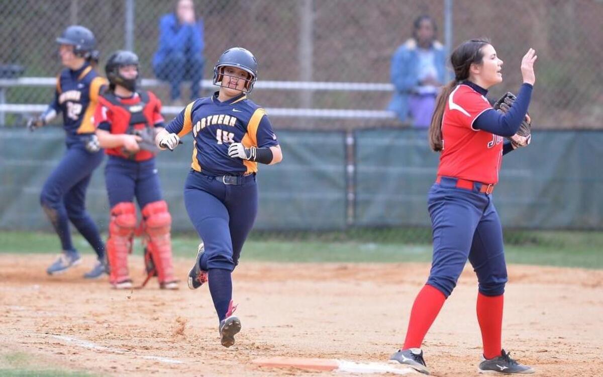 Jessica Wright, second from right, of Northern runs to the 1st base while sending her teammate McKenzie McCullen, left, to home against Jordan's catcher, Sarah Parrott, second from left, and Jordan's 1st baseman Hannah Kauwe, right. The Northern Durham Knights played the Jordan Falcons in a softball game that took place in Durham, N.C. on Friday, March 17 2017. Northern Durham won 21-0.