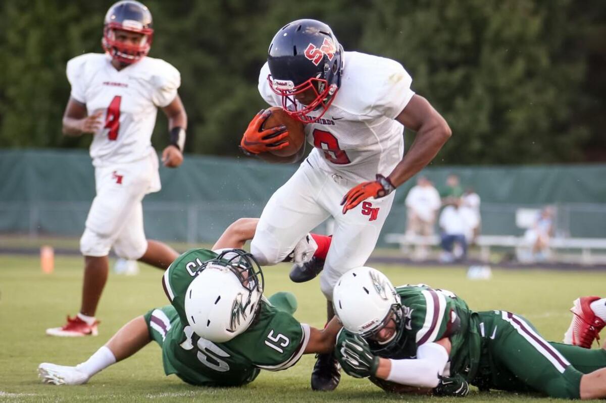 Green Hope defenders Aidan Callahan (15) and Ethan Melton (22) combine to bring down Southern Nash running back Kendrick Bell (6) during the Southern Nash game at Green Hope on Friday, August 18, 2017. Southern Nash won the game 38-28.