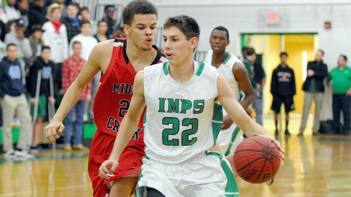 Cary's Cory Gensler (22) drive past Middle Creek's Sheldon Eberhardt during the Middle Creek Mustangs and the Cary Imps boys basketball game in Cary on Tuesday, February 10, 2015. Cary won 66-53.