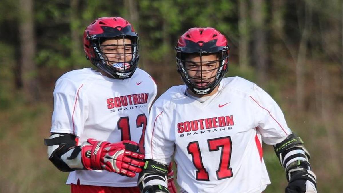 Southern Durham's Jhenson Cruz (12) congratulates Jamea Blank (17) after he scores during the Southeast Raleigh Bulldogs high school lacrosse game with the Southern Durham high school on April 5, 2017. Southeast Raleigh won the game 5-4.