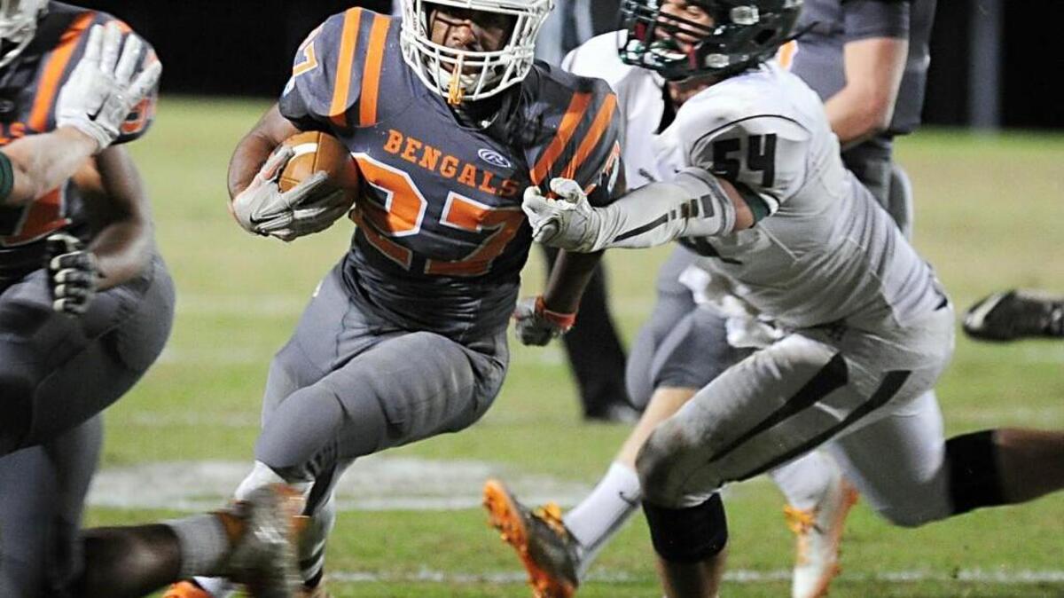 Fuquay-Varina’s Josh Arrington (27) is pursued by Green Hope's Eric Zimmerman (54) during the NCHSAA first-round 4AA football playoff game, which was played on Friday, November 13, 2015 in Fuquay-Varina.