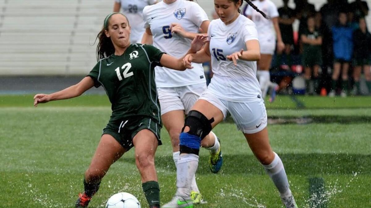 Durham Academy’s Jaya Perentis (12) and Cary Academy’s Lillian Lee (15) battle for possession during Friday afternoon's NCISAA semifinals between Cary Academy and Durham Academy.