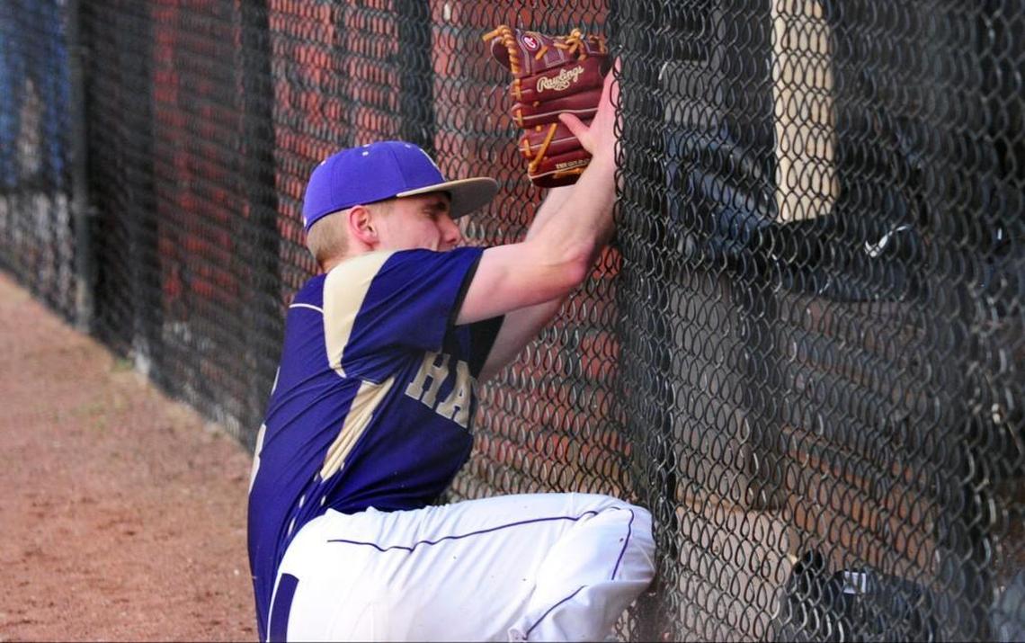 Holly Springs pitcher Camden Munise slams into the dugout fence chasing a foul ball during the baseball game, which was played in Holly Springs on Tuesday, March 7, 2017. Holly Springs won 10-0.