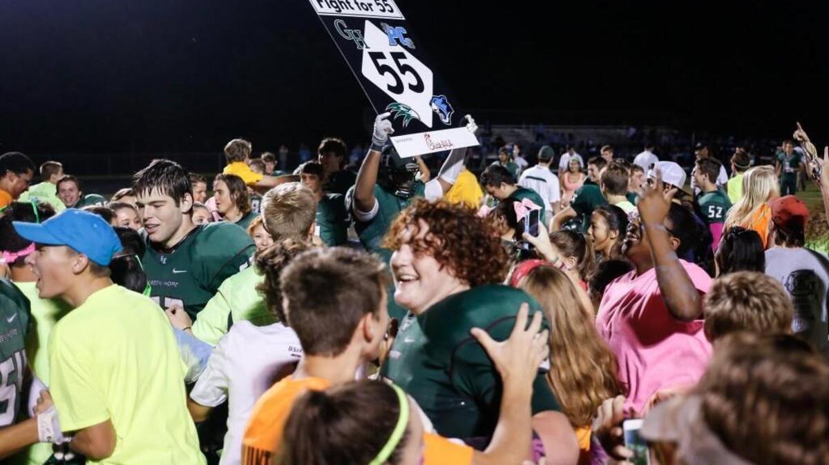 
Green Hope’s Keanu Gonzales (51), center, holds a sign as the students and players celebrate following Panther Creek's football game at Green Hope on Friday, October 9, 2015. Green Hope won the game 28-27.

