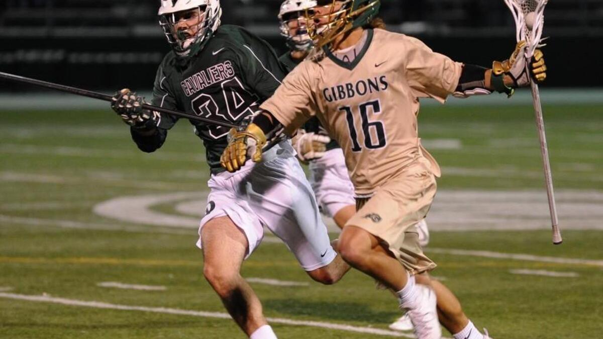 Durham Academy's Sam Frey (34) and Cardinal Gibbons' Jack Shelton (16) move in stride up the field during the boys lacrosse game, which was played in Raleigh on Friday, March 4, 2015. Cardinal Gibbons won 16-7.
