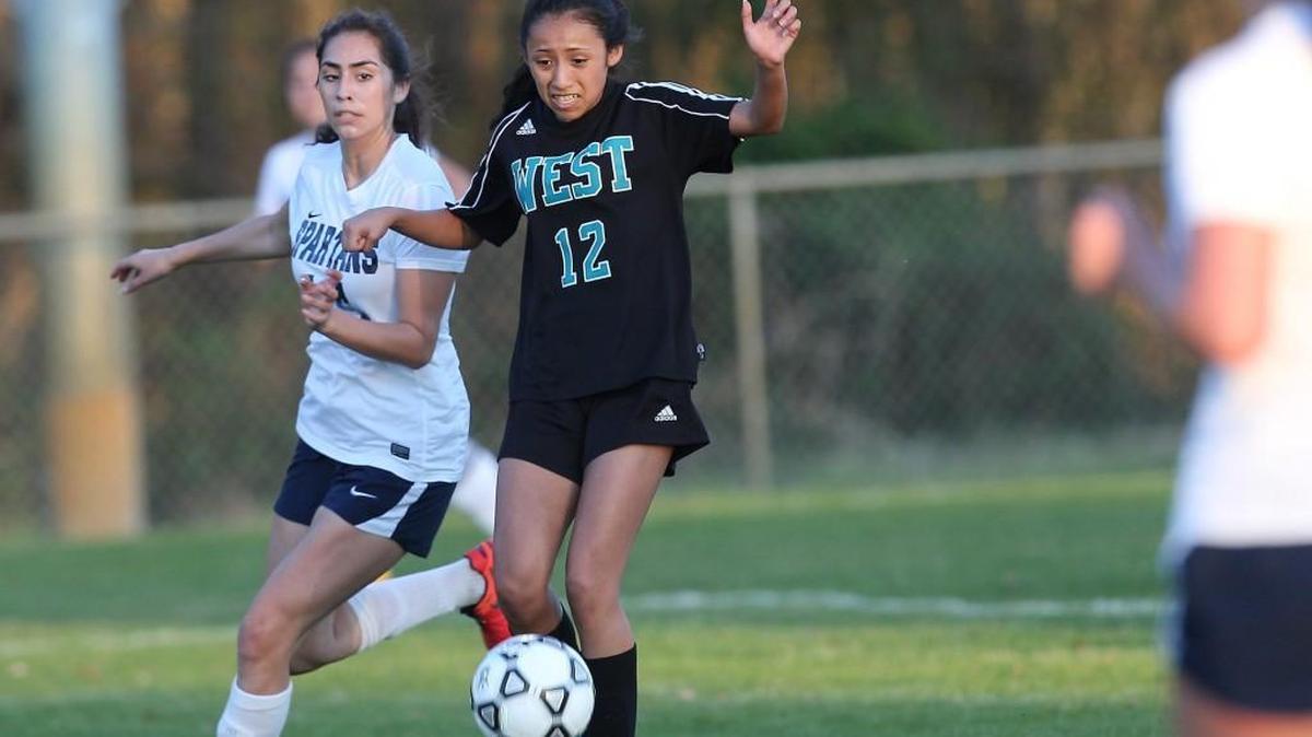 West Johnston’s Fabiola Martinez (12) runs the right side as Smithfield-Selma’s Ashley Garcia (14) defends.