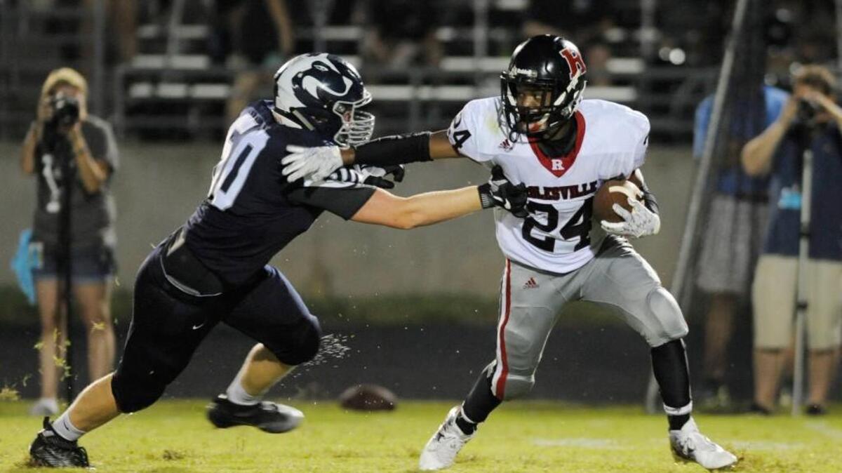Heritage's Randy Davis (50) tries to tackle Rolesville's Kishawn Bobbitt (24) in Wake Forest, N.C. on Friday, August 26, 2016. Heritage beat Rolesville 28-0.
