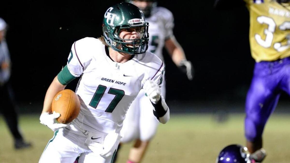 
Green Hope's Tucker Burkinshaw (17) runs through a tackle by Holly Springs' Greg Picquet (21) to score a touchdown. The Green Hope Falcons football team played the Holly Springs Golden Hawks in Holly Springs on Friday, October 24, 2014. Green Hope won 20-17.
