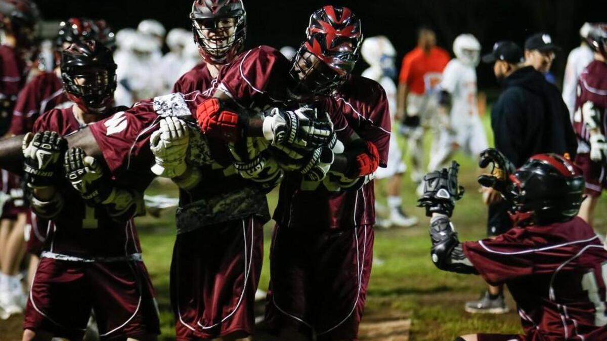 Wakefield players on the bench celebrate a late goal with Rodney McLaurin, lying down, pretending to be a trophy fish while Ryan Geary (18) pretends to take a photo during Wakefield's boys lacrosse game at Athens Drive on Wednesday, April 13, 2016. Wakefield won the game 11-6.