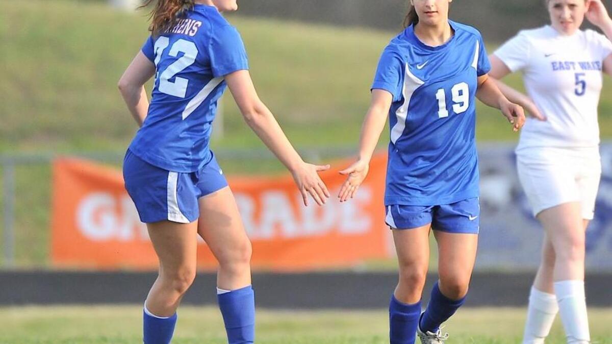 Athens Drive's Kayla Cooper (22) congratulates teammate Rachel Snyder (19) after her goal during the first half. The East Wake Warriors took on the Athens Drive Jaguars in a non-conference game in Wendell, N.C. on April 21, 2016. Athens Drive won 6-0.
