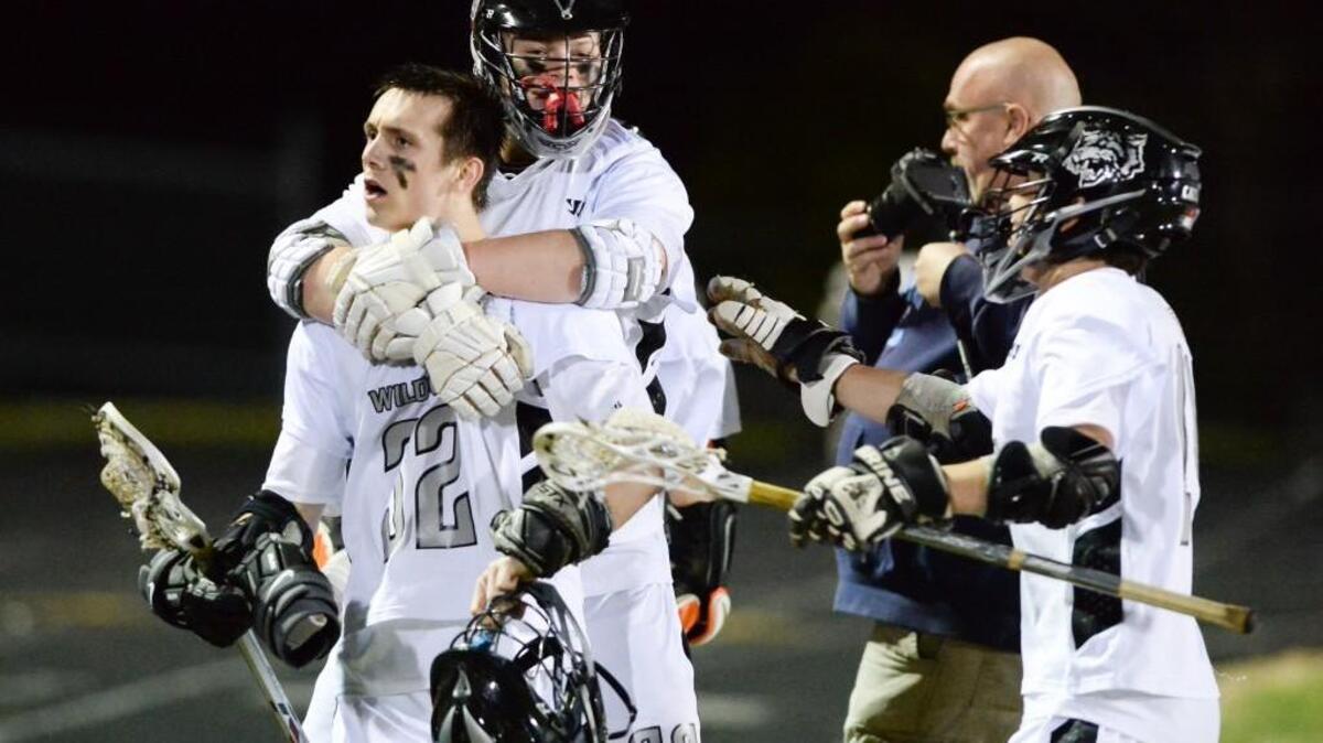Chris Cox, left, of East Chapel Hill celebrates along his teammates Peter Klein, center and Tyler Westerhoff, right, after scoring the winning goal for the Wildcats. The East Chapel Hill Wildcats played the Chapel Hill Tigers in Chapel Hill, N.C. on Friday, March 18, 2016. East Chapel Hill won 7-6 after double overtime.