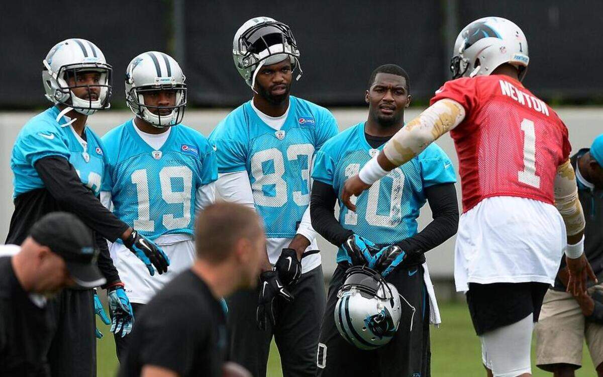 
Carolina Panthers quarterback Cam Newton, right, runs over to slap hands with wide receivers (from left) Corey Brown, Ted Ginn Jr., Marcus Lucas and De’Andre Presley before beginning drills during practice on June 4, 2015.
