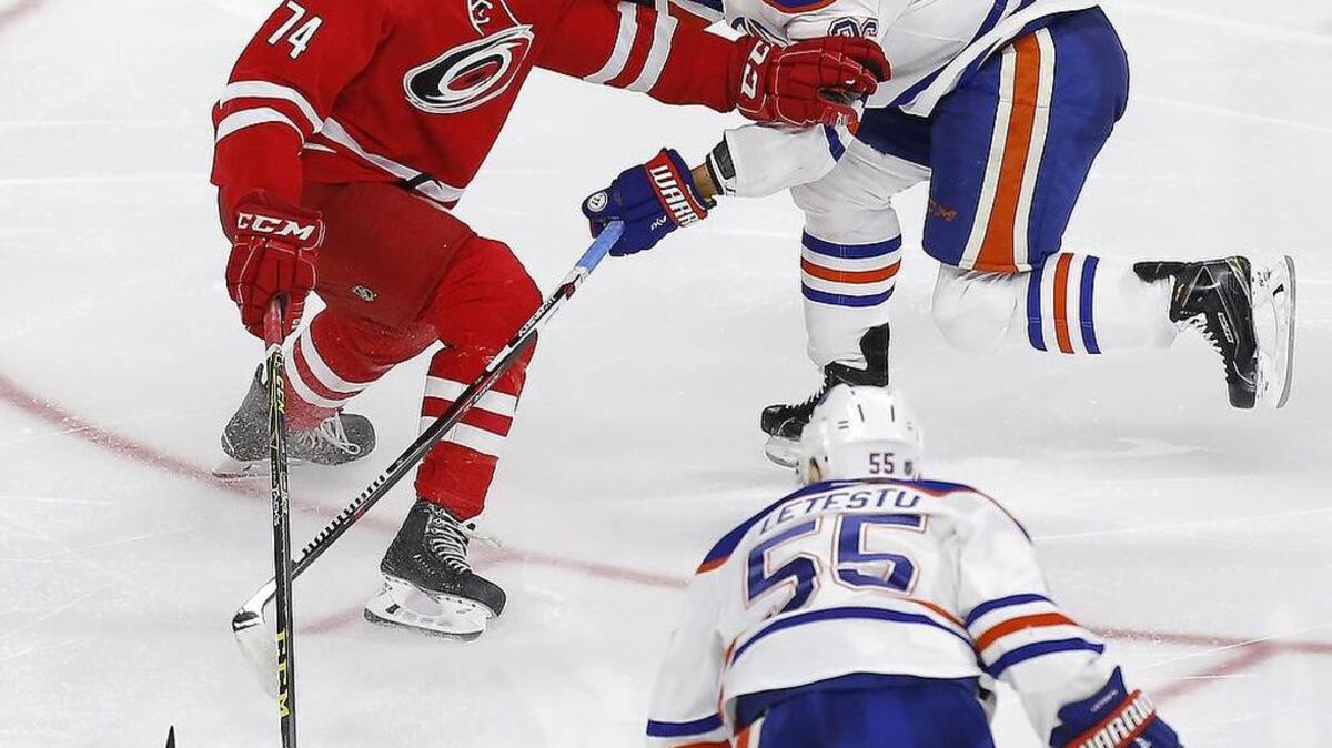The Canes Jaccob Slavin (74) battles against the Edmonton Oilers' Mark Letestu (55) and Iiro Pakarinen (26) during the third period.