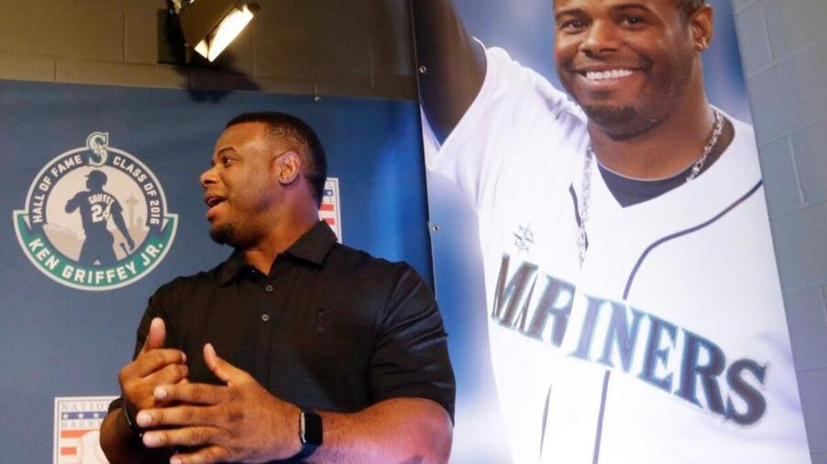 Former Seattle Mariners' Ken Griffey Jr. stands near a photo of him from his playing day following a news conference Friday, Jan. 8, in Seattle. Griffey's Hall of Fame whirlwind came back to where it all started, when he spoke at Safeco Field, the stadium built in part because of him. (AP Photo/Elaine Thompson)