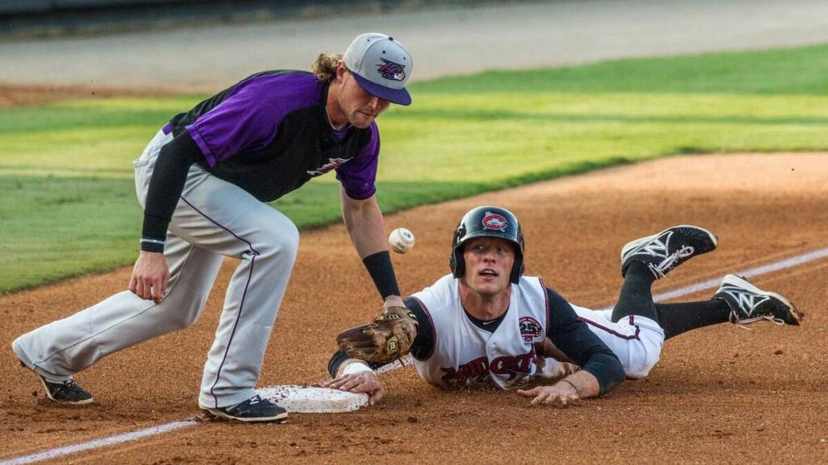 
Mudcats outfielder Connor Lien (34) slides safely into third base as Winston-Salem Dash's Trey Michalczewski bobbles the ball Thursday, July 16, 2015 at Five County Stadium in Zebulon. Lien went on to score a run.
