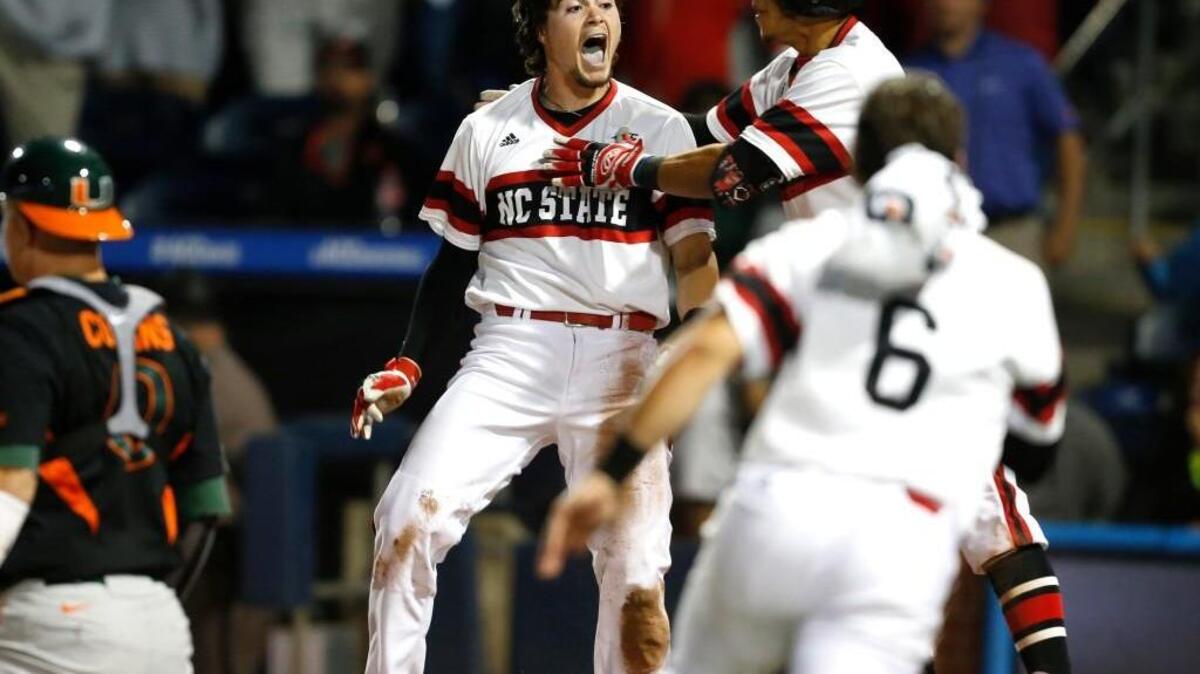 N.C. State's Preston Palmeiro (12), center, celebrates after scoring in the 12th inning during N.C. State's 5-4 victory over Miami in 12 innings in the ACC Baseball Tournament at the Durham Bulls Athletic Park in Durham, N.C., Friday, May 22, 2015.