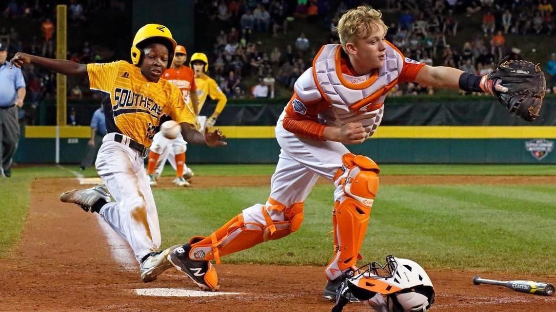 Lufkin, Texas, catcher Chandler Spencer, right, can't handle the throw from first baseman Mark Requena, allowing Greenville, N.C.'s Cash Daniels-Moye to score the winning run on a ball hit by Thomas Barrett.