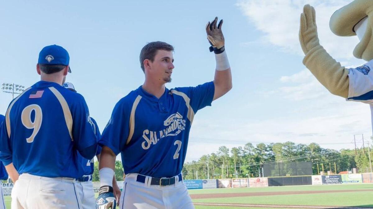 Holly Springs Salamanders all-star Dillon Stewart slaps fives with the mascot. Stewart grew up in Coats, N.C. and went to Triton High.