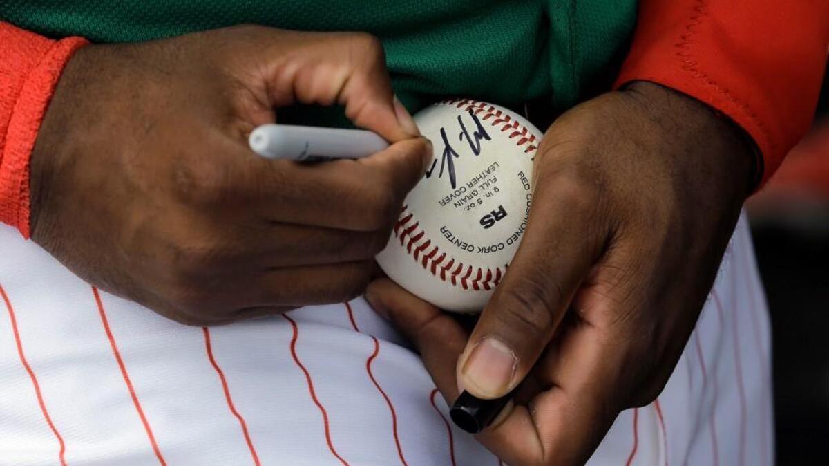 Philadelphia Phillies' Maikel Franco signs an autograph for a fan before a spring training baseball game against the Tampa Bay Rays Thursday, March 17, 2016, in Clearwater, Fla. (AP Photo/Chris O'Meara)
