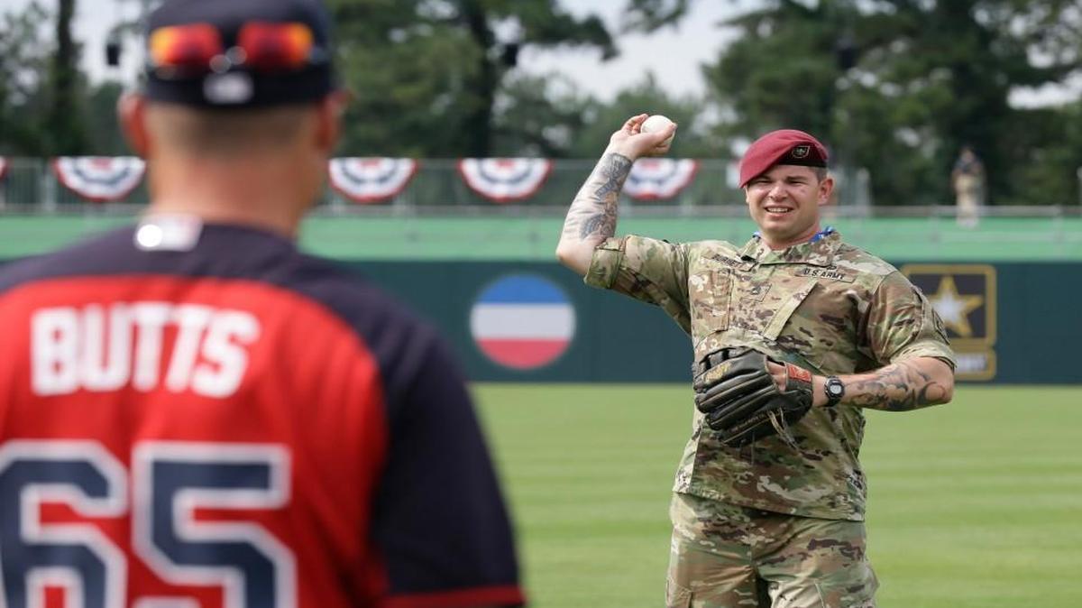 U.S. Army Sergeant Alex Burnett of the 82nd Airborne Division throws the ball with Atlanta Braves assistant bullpen coach Alan Butts, left, prior to a baseball game against the Miami Marlins in Fort Bragg, N.C., Sunday, July 3, 2016. The event marks the first regular season game of a professional sport ever played on an active military base, the first of it's kind in celebration of the nation's servicemen and servicewomen.