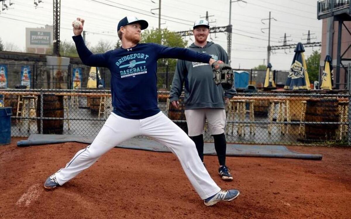 Dan Johnson, the journeyman first baseman, works on his knuckleball as Jesse Kitsch looks on during a practice with the Bridgeport Bluefish in Bridgeport, Conn., May 7, 2016. Johnson has some memorable clutch hits on his resume, but to extend his major league career, he’s turning to the knuckler, a pitch he as tinkered with since childhood.