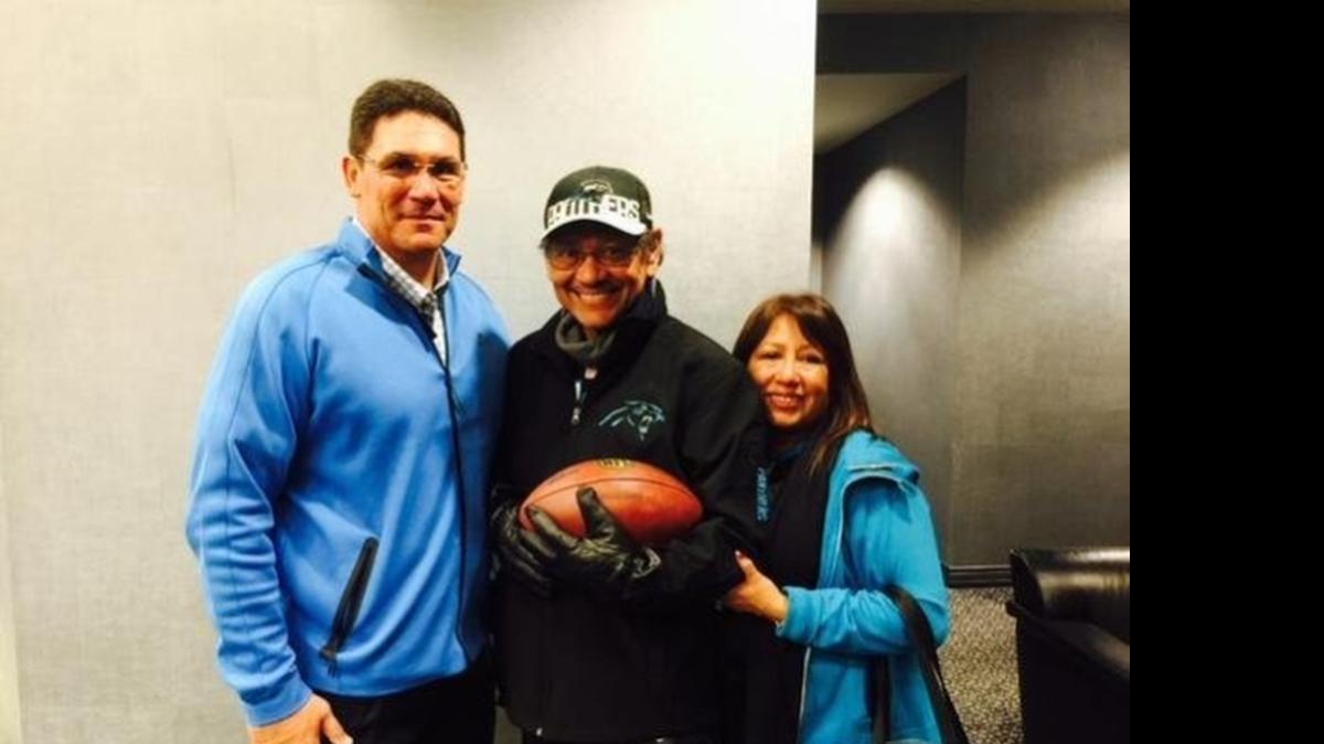 
Carolina Panthers coach Ron Rivera (left) presented a game ball to his older brother, Mickey (center, with wife Rosemary), after the Panthers beat the Arizona Cardinals 27-16 on Jan. 3. Mickey Rivera, who was battling pancreatic cancer, died Tuesday. 
