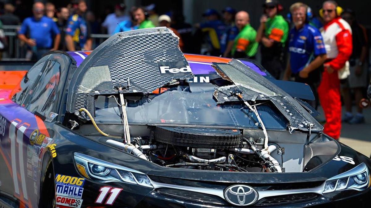 
Denny Hamlin, driver of the #11 FedEx Express Toyota, drives back to the garages after his hood flew up during practice for the NASCAR Sprint Cup Series Crown Royal Presents the Jeff Kyle 400 at the Brickyard at Indianapolis Motorspeedway on July 24, 2015 in Indianapolis, Indiana. 
