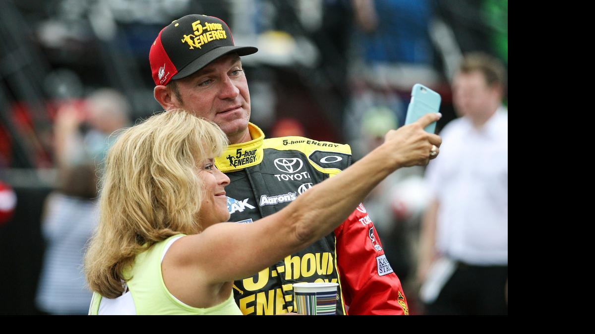 
Driver Clint Bowyer has a selfie taken with a fan as he heads to his garage at the start of practice for Sunday's NASCAR Sprint Cup series auto race at New Hampshire Motor Speedway, Loudon, N.H., Saturday, July 18, 2015. 
