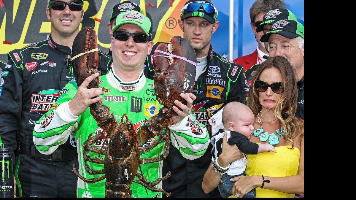 
Kyle Busch holds the Loudon lobster trophy in Victory Lane, as his wife, right, Samantha holding son Brexton looks on, after winning the NASCAR Sprint Cup series auto race at New Hampshire Motor Speedway, Loudon, N.H., Sunday, July 19, 2015 
