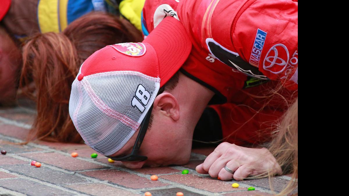 
Kyle Busch kisses the bricks on the start/finish line after winning the NASCAR Brickyard 400 auto race at Indianapolis Motor Speedway in Indianapolis, Sunday, July 26, 2015.
