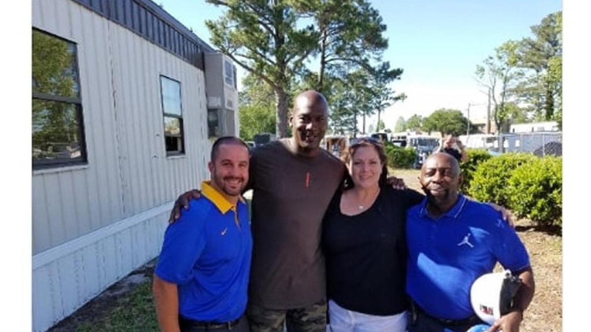 Michael Jordan poses with Laney High School assistant principal Aaron Livengood, principal Sharon Dousharm and athletic director Fred Lynch. Jordan was back at his alma mater to film a Gatorade commercial.