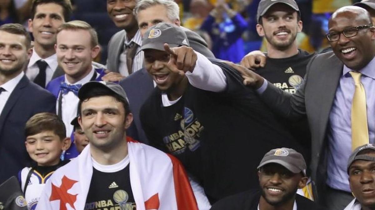 The Golden State Warriors, including David West, top center, celebrate with the Larry O'Brien Championship Trophy after defeating the Cleveland Cavaliers 129-120 in Game 5 to win the 2017 NBA Finals at ORACLE Arena on June 12, 2017 in Oakland, California.
